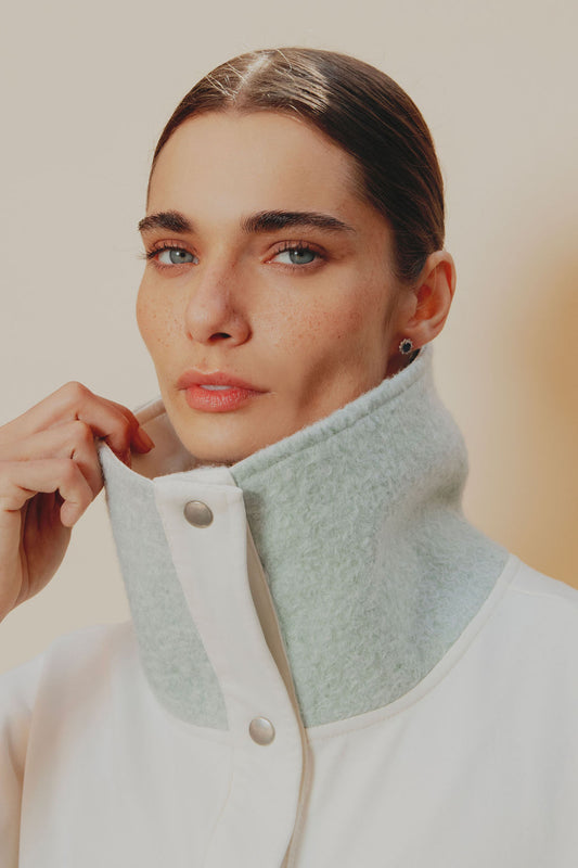 Chaleco deportivo semi oversized en algodón crudo, con cuello y solapas en tela ovejera baby blue y cordones ajustables del mismo tono.