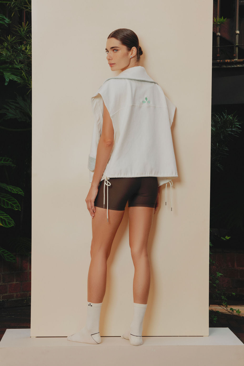 Chaleco deportivo semi oversized en algodón crudo, con cuello y solapas en tela ovejera baby blue y cordones ajustables del mismo tono. 